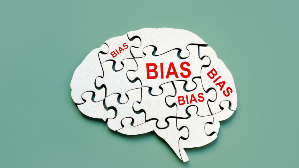 A picture of a puzzle in the shape of a brain with the word bias on some of its tiles. this image is attached to a blog article about avoiding status quo bias in cybersecurity. This paper you’ll get an insight into the tendency towards status quo bias, which leads individuals and companies to resist change and stick to familiar ways of doing things.