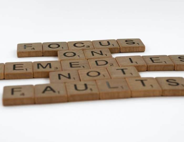 A picture of wooden scrabble showing the words focus on remediation not faults depicting