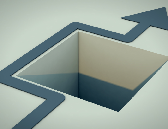 A light grey illustration of a square hole in the ground with a blue arrow winding around it is shown to represent the concept of zero-day vulnerabilities and the importance of avoiding them